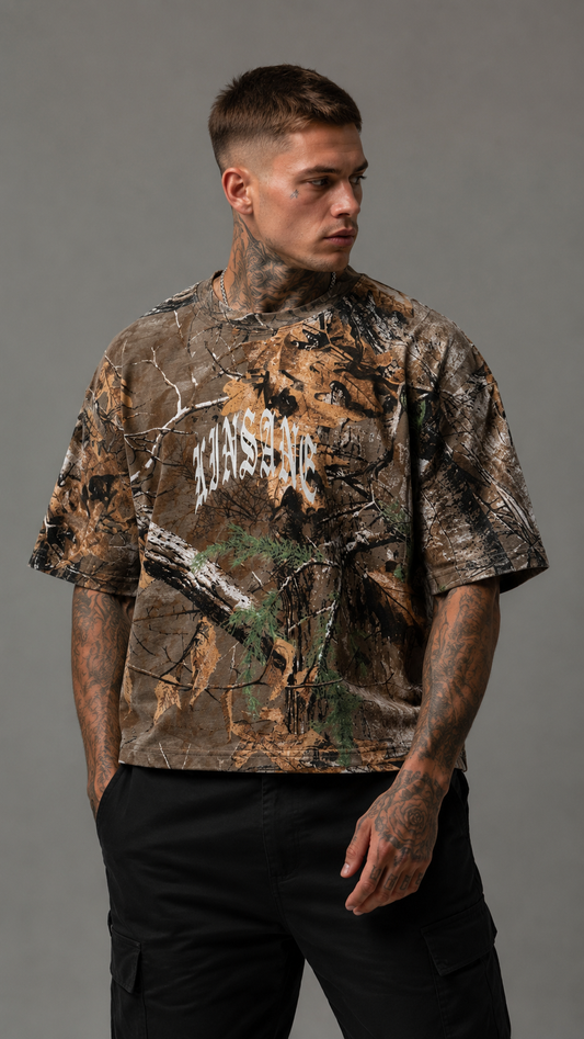 Man wearing Camouflage t shirt with white text on the front reading “KINSANE”