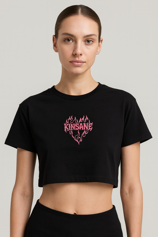 Girl wearing a black crop top T-shirt with pink lettering reading “KINSANE” surrounded by pink flames in the shape of a heart