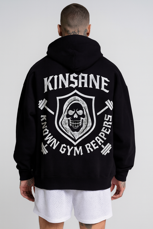 Back view of a man wearing a black hoodie with a white reaper and barbell logo and lettering reading “KINSANE” and “KNOWN GYM REAPERS”