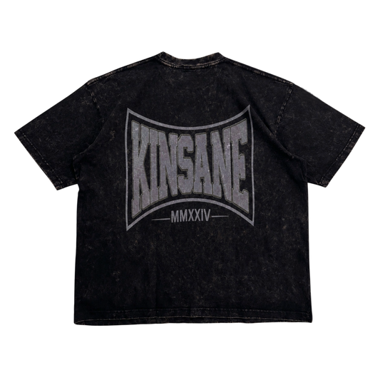 Back view of a acid washed black t shirt with grey logo and text reading “KINSANE MMXXIV”