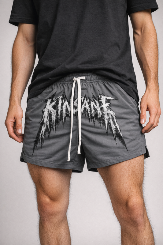 Man wearing Grey athletic shorts with white drawstrings and white lettering across the middle reading “KINSANE”