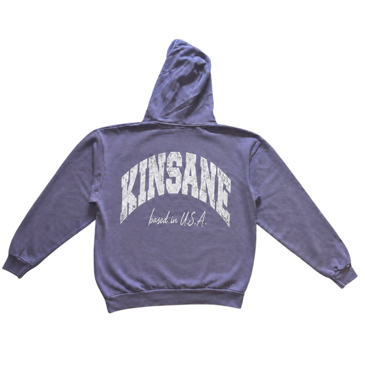 Back view of a light blue hoodie with white text reading “KINSANE BASED IN U.S.A.”