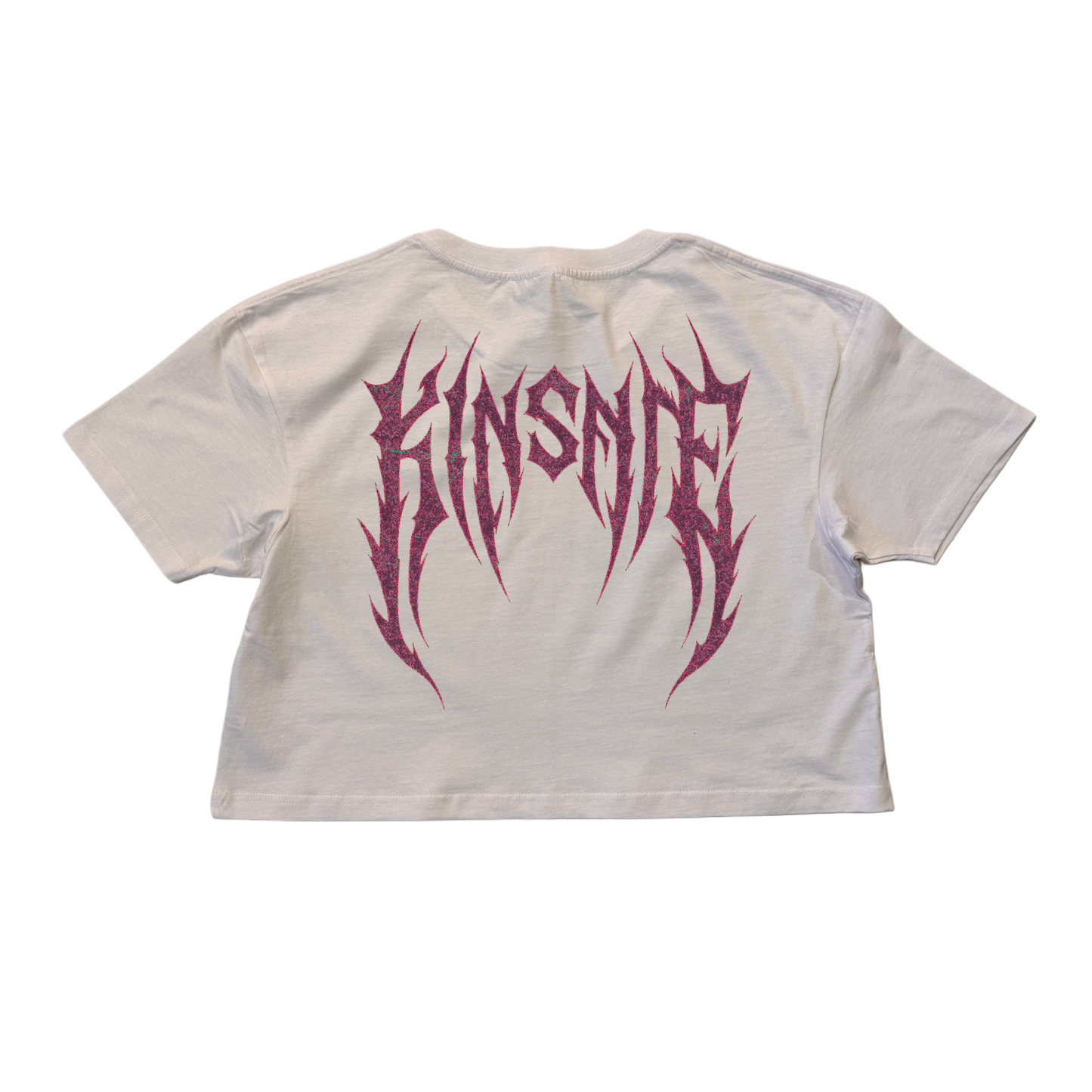 Back view of a white crop top T-shirt with dark purple tribal lettering reading “KINSANE” 
