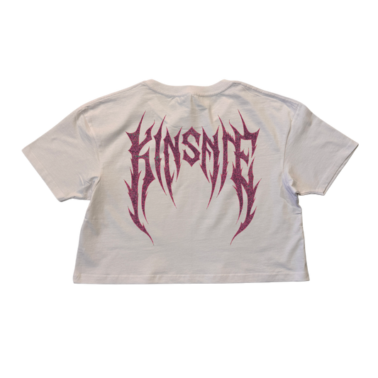 Back view of a white crop top T-shirt with dark purple tribal lettering reading “KINSANE” 