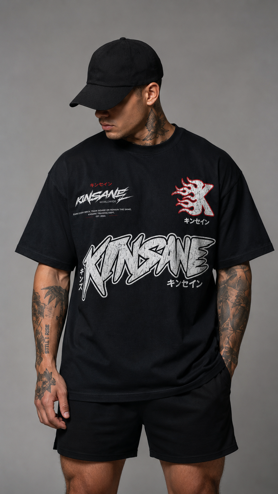 Man wearing Black  graphic T-shirt featuring distressed KINSANE branding, Japanese text accents, a flame-style K chest logo, and bold athletic streetwear graphics.