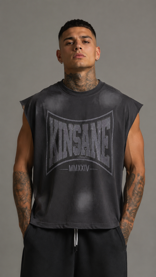 Man wearing Gray acid washed sleeveless shirt with grayish logo and lettering reading “KINSANE MMXXIV” 