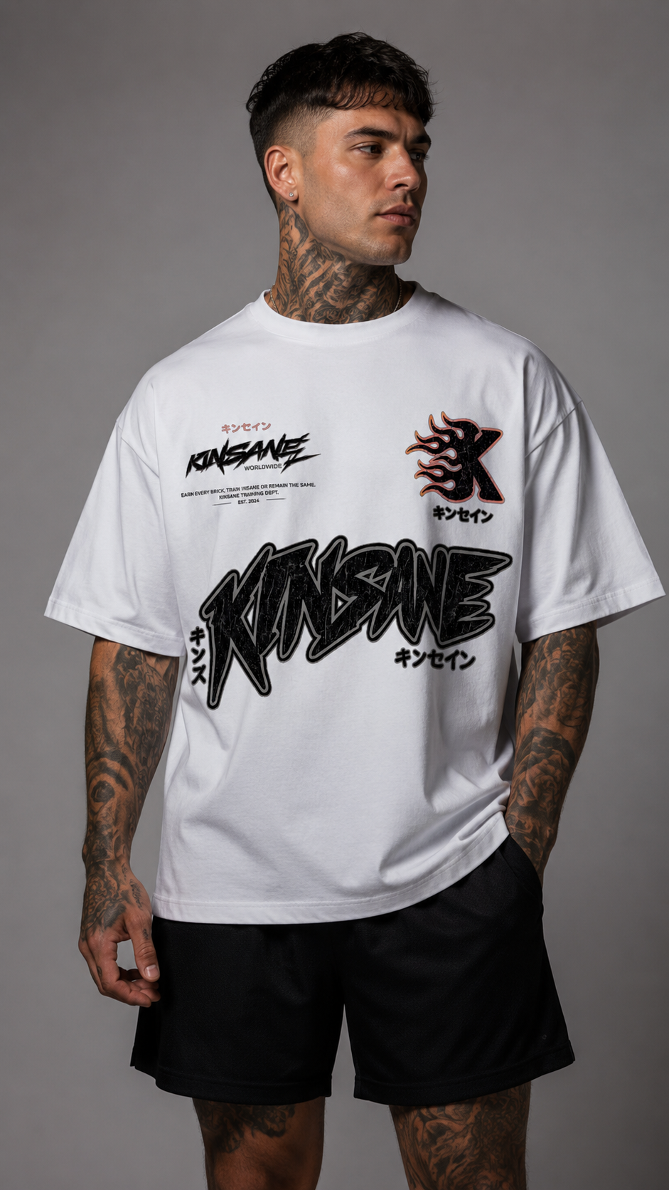 Man wearing White T-shirt featuring distressed KINSANE branding, Japanese text accents, a flame-style K chest logo, and bold athletic streetwear graphics.