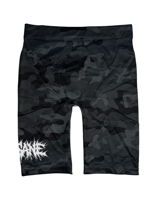 Back view of Black and grey camo compression shorts with white chaotic lettering reading “SANE” on the left leg 