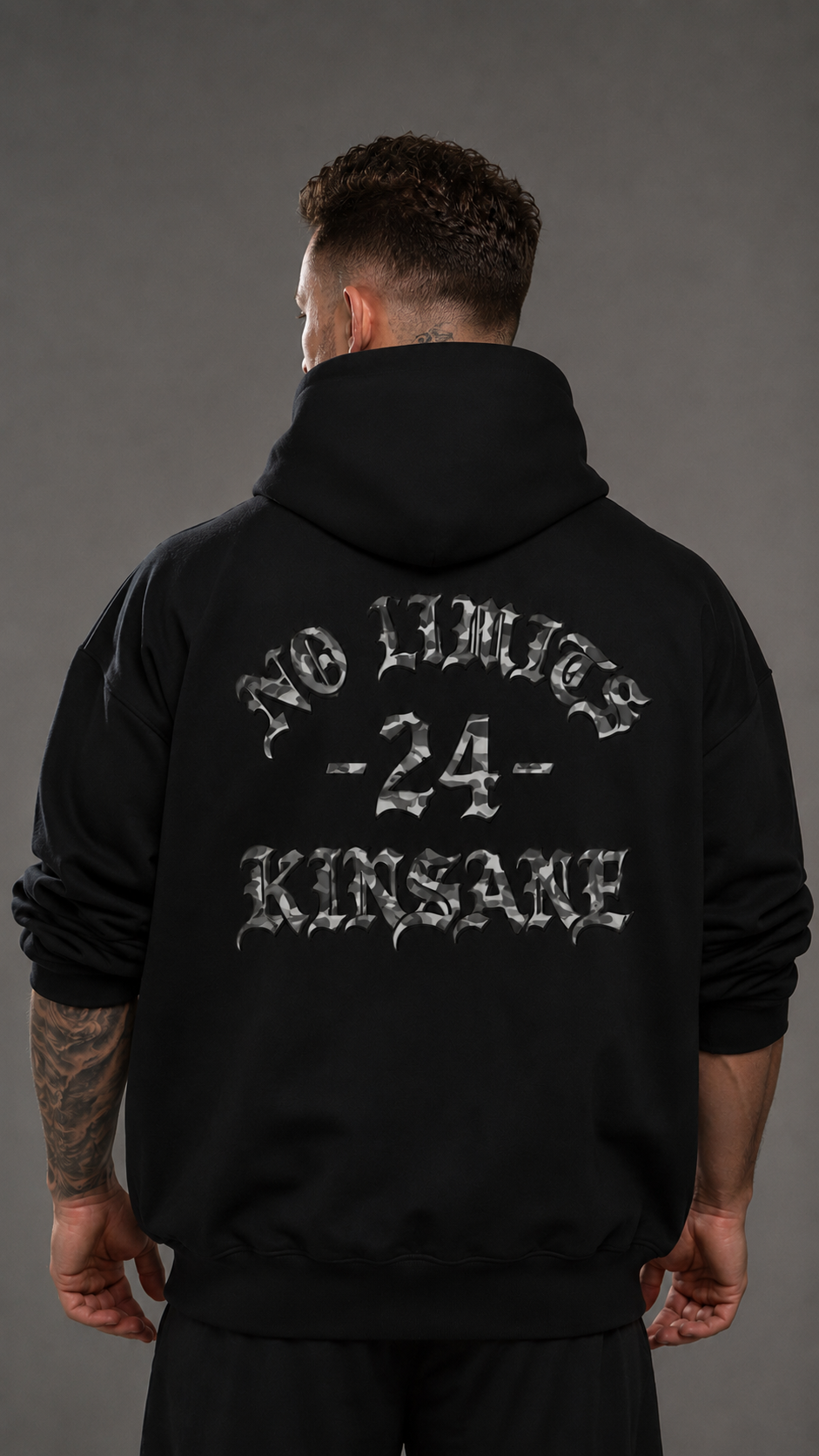 Back view of a man wearing a black hoodie with white and gray camo filtered text reading “NO LIMITS -24- KINSANE” 