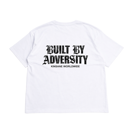 Back view of a white t shirt with black text reading “BUILT BY ADVERSITY KINSANE WORLDWIDE” 