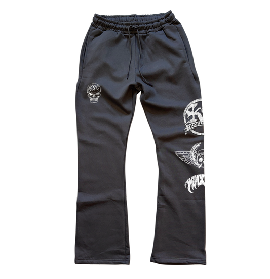 Gray stacked sweatpants with white skull logo on the right leg and white logos stacked on top of each other on the left leg that say “KS WORLDWIDE, MMXXIV” 