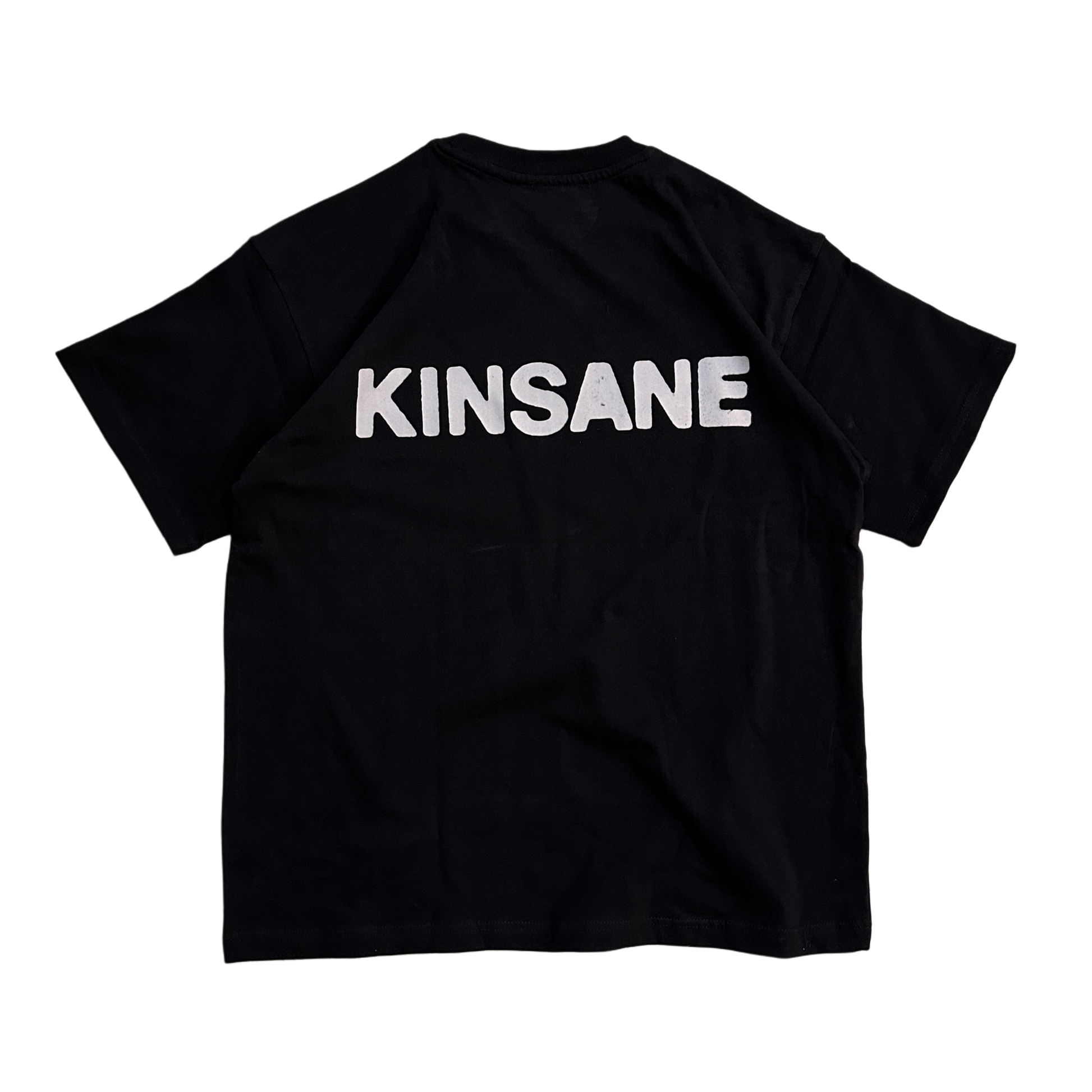 Back view of a black T-shirt with white text reading “KINSANE” 