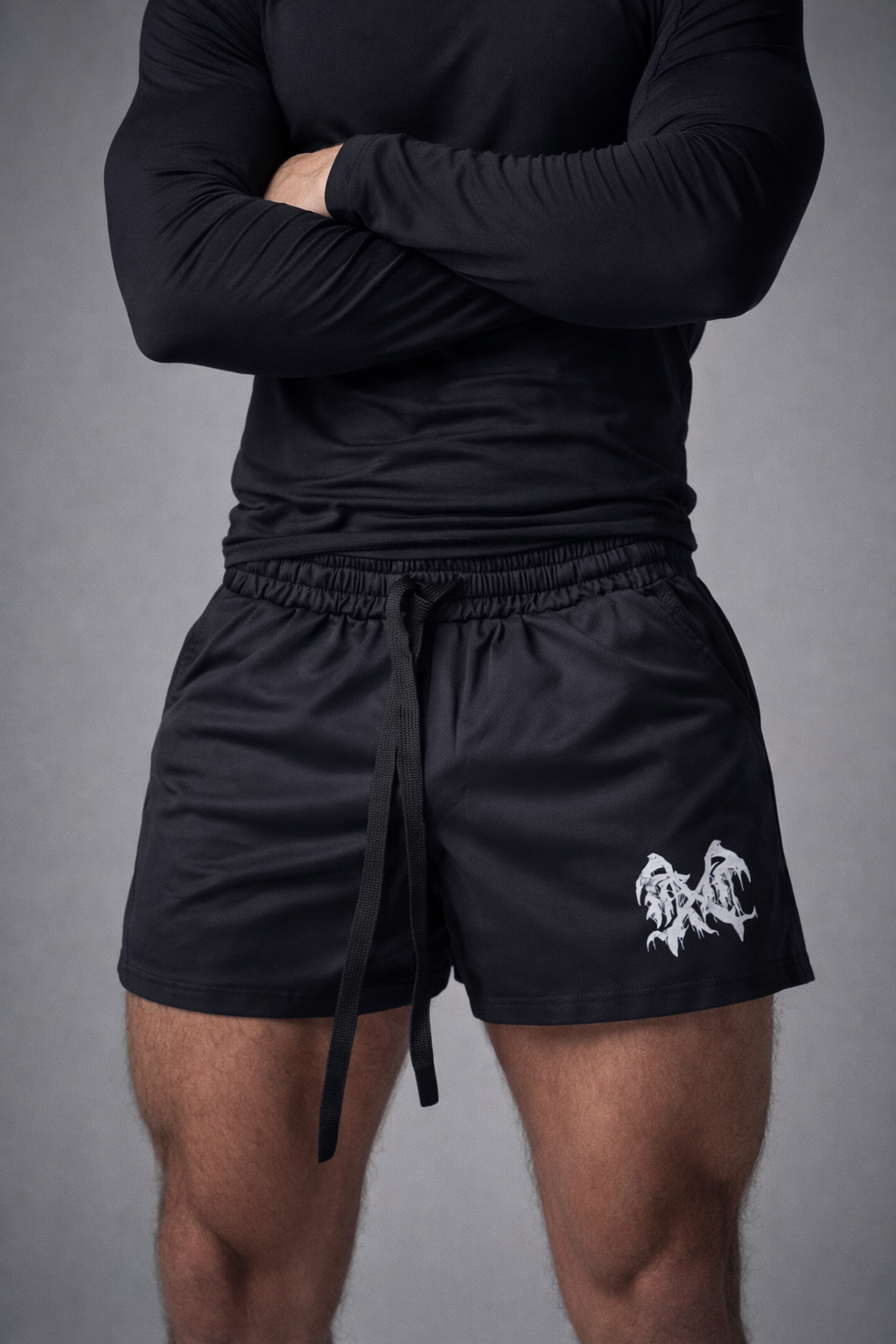 person with black shirt wearing black athletic shorts with elastic waistband, drawstrings, and white graphic logo on right leg