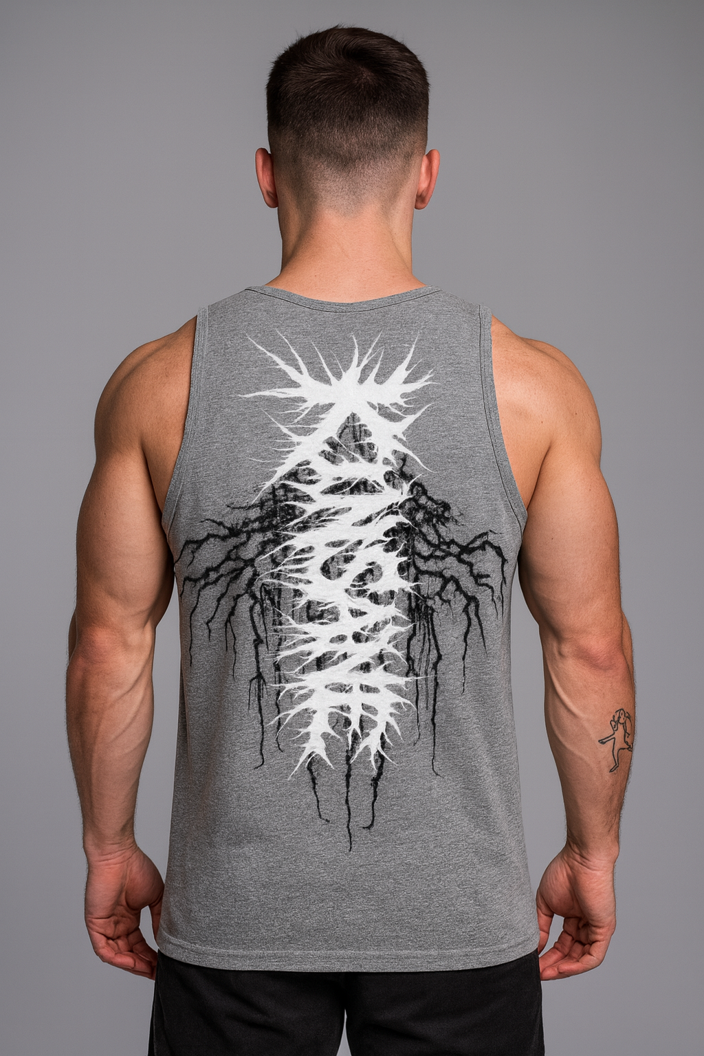Back view of a Man wearing a gray tank top with white chaotic lettering reading “KINSANE” on top of black tribal cracks 