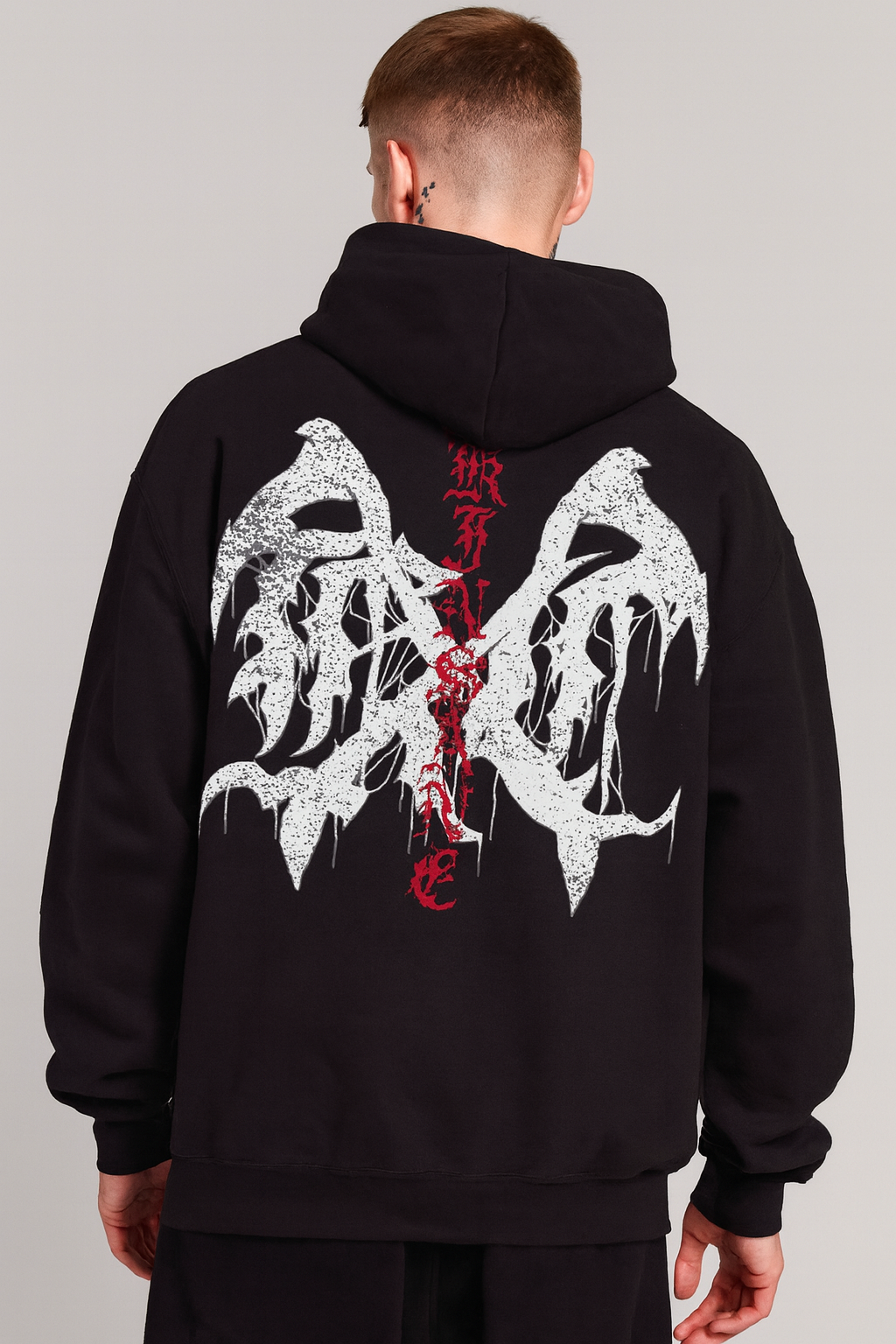 Back view of a man wearing a black hoodie with a white logo and red lettering reading “KINSANE” 