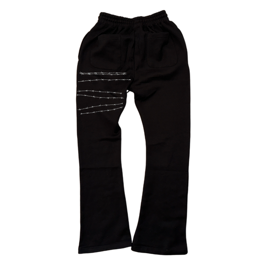 Back view of black stacked sweatpants with white barbed wire on the left side 