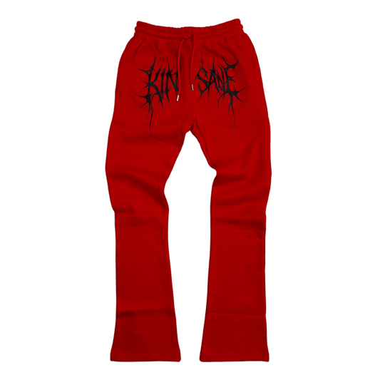 Red stacked sweatpants with black tribal lettering across the middle reading “KINSANE” 