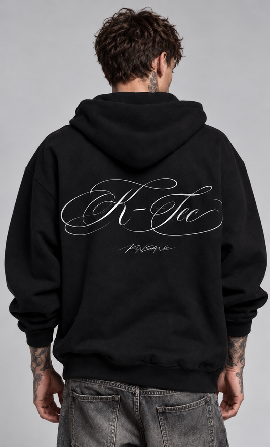 Back view of a man wearing a black hoodie with white cursive text reading “K-Tec” and “Kinsane” 