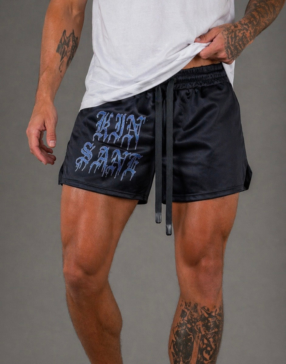 Man wearing Black athletic shorts with elastic waistband and black drawstrings and blue lettering reading “KINSANE” on the right leg 