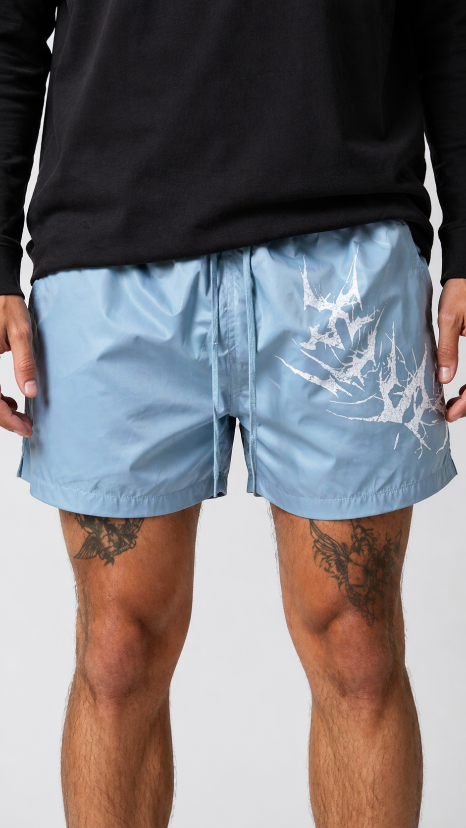 Man wearing Light blue shorts with light blue drawstrings and white lettering on the left leg reading “KINSANE”