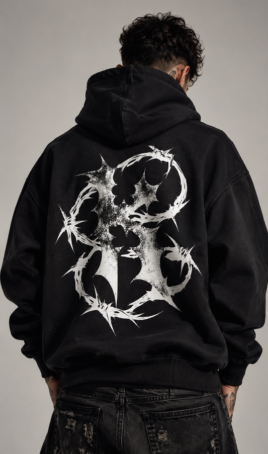 Back view of a man wearing a black hoodie with white barbed wire “K” design 
