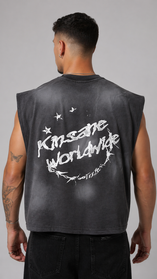 Back view of a man wearing a vintage washed grey shirt with white text and star / barbed wire logo reading “KINSANE WORLDWIDE” 