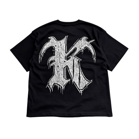 Back view of a black t shirt with a white and black logo of the letter “K”