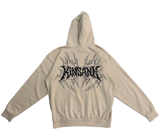 Back view of a beige hoodie with black tribal designs and black lettering reading “KINSANE” 