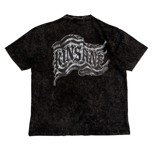 Back view of a black acid washed t-shirt with a black and white flag and black lettering reading “KINSANE” 