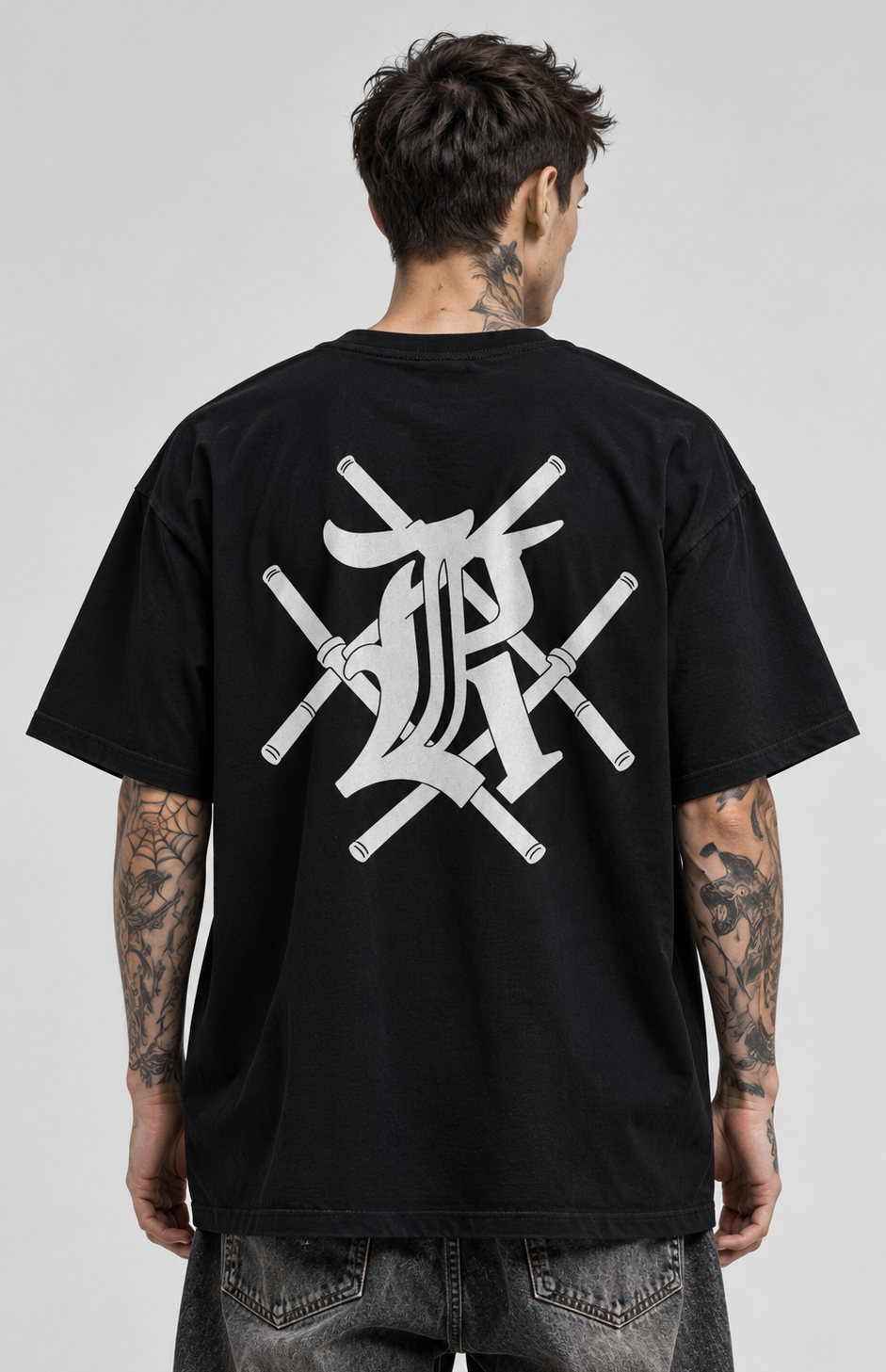 Back view of a man wearing a black t shirt with white design of bars crossing and the letter K 