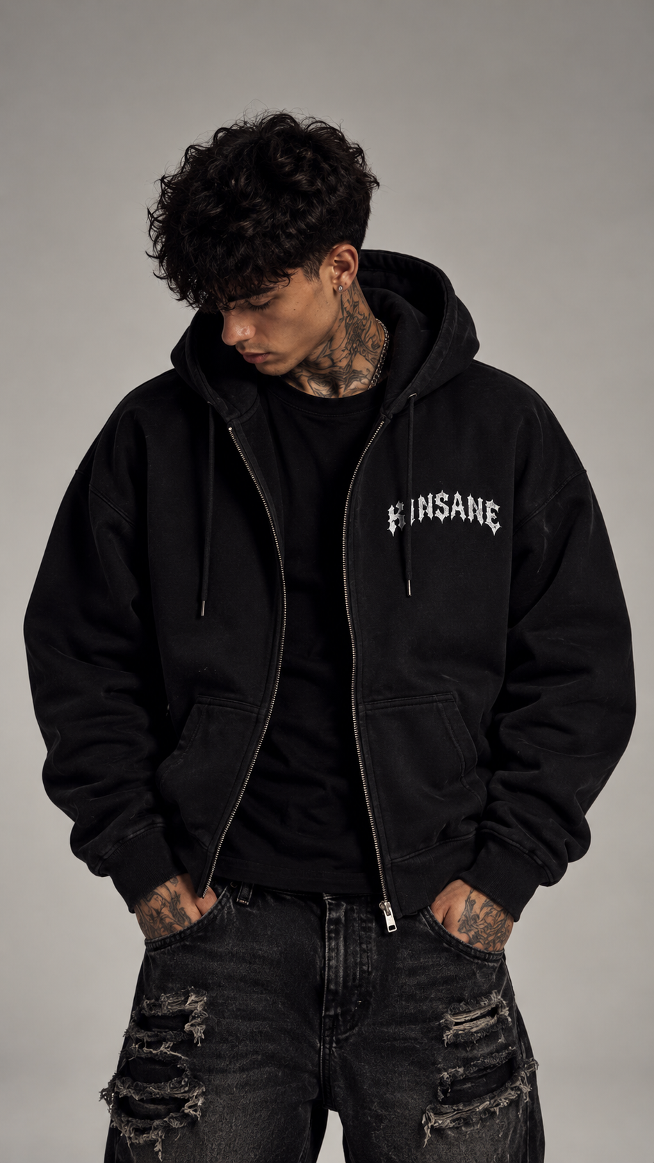 Man wearing Black zip up hoodie with white text on the right side reading “kinsane” 