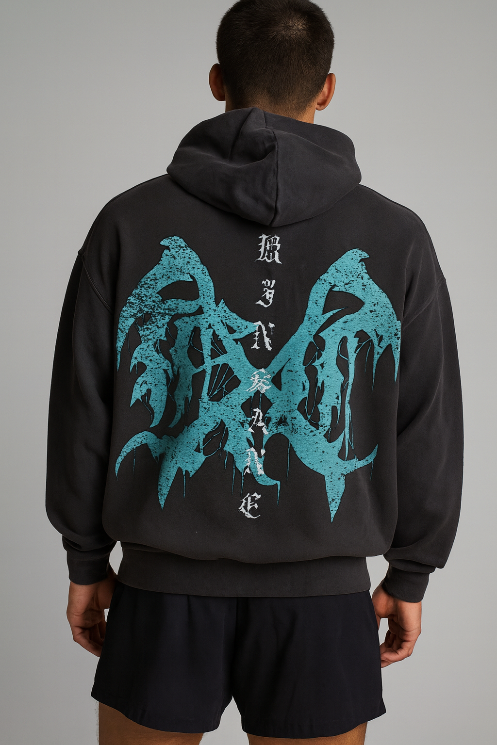 Back view of a guy wearing a dark grey hoodie with a teal logo and white text reading “KINSANE” 