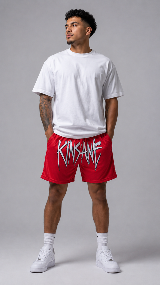Man wearing Red mesh shorts with red drawstrings and white text across the front reading “KINSANE”