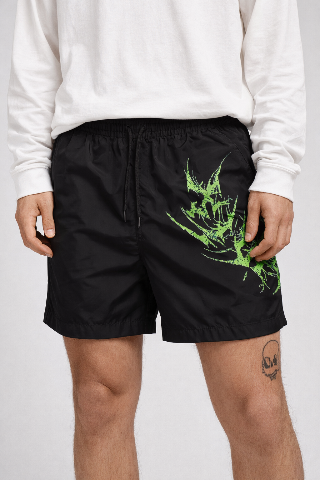 Man wearing Black shorts with black drawstrings and neon green lettering on the left leg reading “KINSANE”