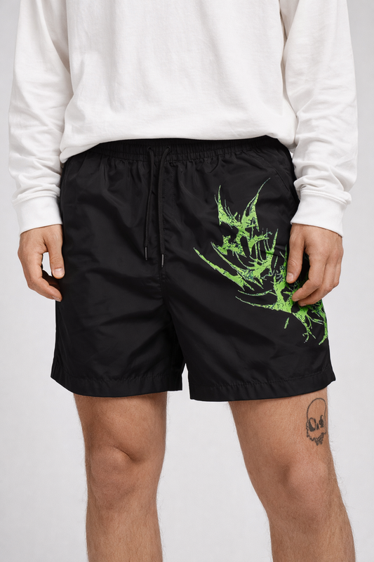 Man wearing Black shorts with black drawstrings and neon green lettering on the left leg reading “KINSANE”