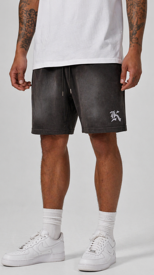 Man wearing Gray vintage washed shorts with grey drawstrings and white “K” logo on the left leg 