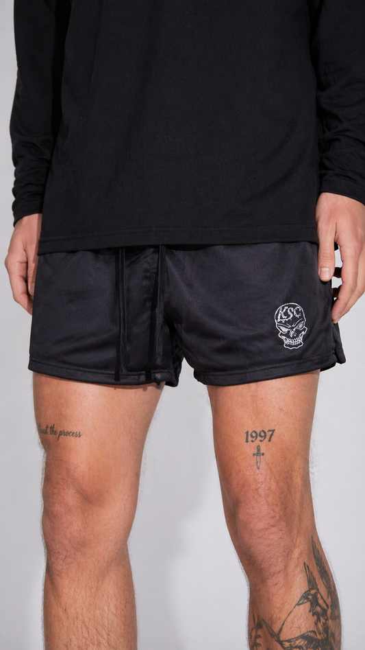 Man wearing Black athletic shorts with black drawstring and a white skull logo with white letters reading “KSC” on the left leg 