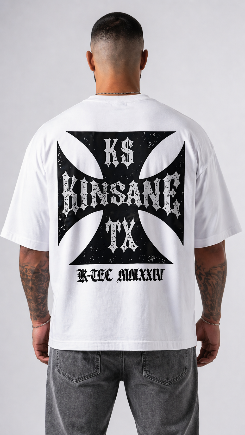 Back view of a man wearing a white t shirt with black logo and white text reading “KS KINSANE TX” and black text reading “K-TEC MMXXIV” 