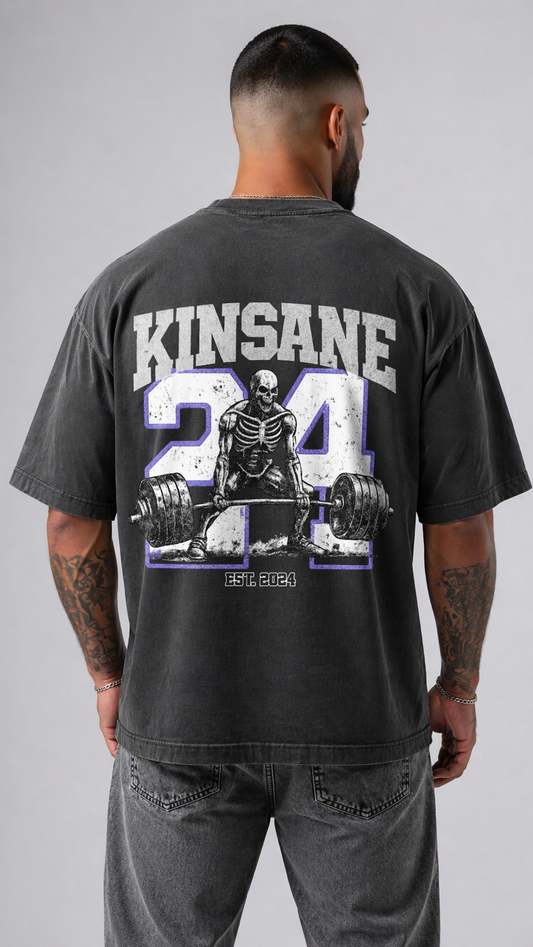 Back view of a man wearing a gray t shirt with white logo of a skeleton lifting weights and blue outlined “24” and white text reading “KINSANE” and “est 2024” 