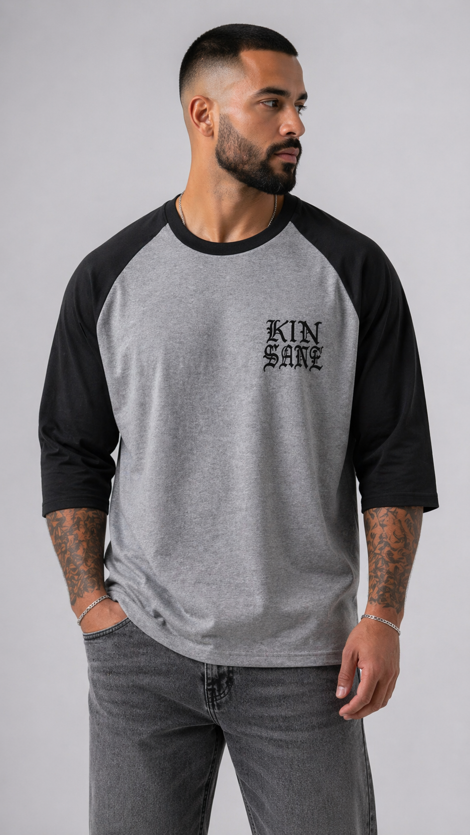 Man wearing Black and grey raglan baseball shirt with black text reading “KINSANE” 