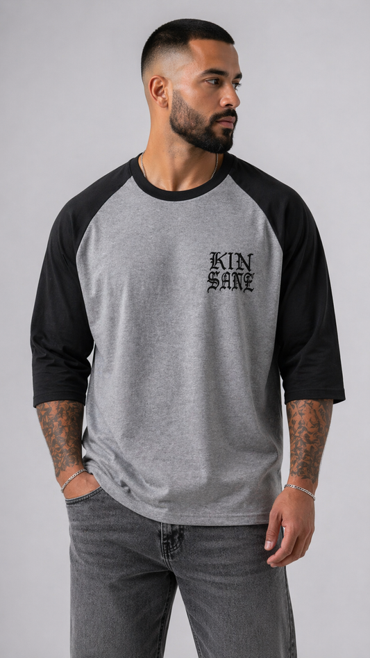 Man wearing Black and grey raglan baseball shirt with black text reading “KINSANE” 