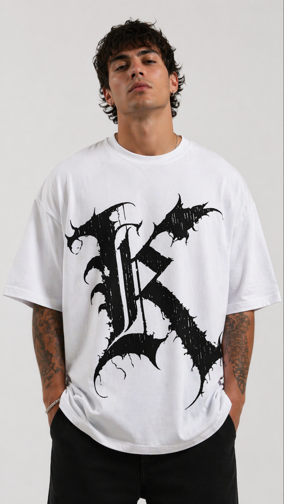 Man wearing White t shirt with black letter “K” on the front 
