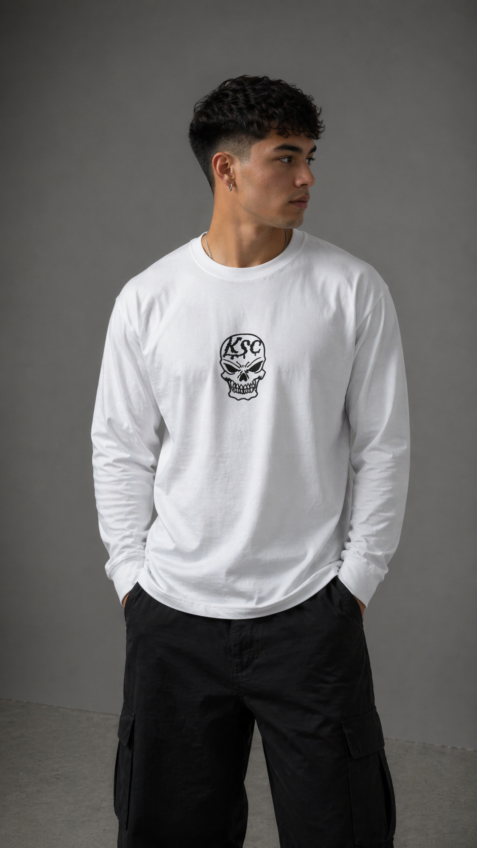Man wearing White long sleeve shirt with black skull logo with black Text reading “KSC” 