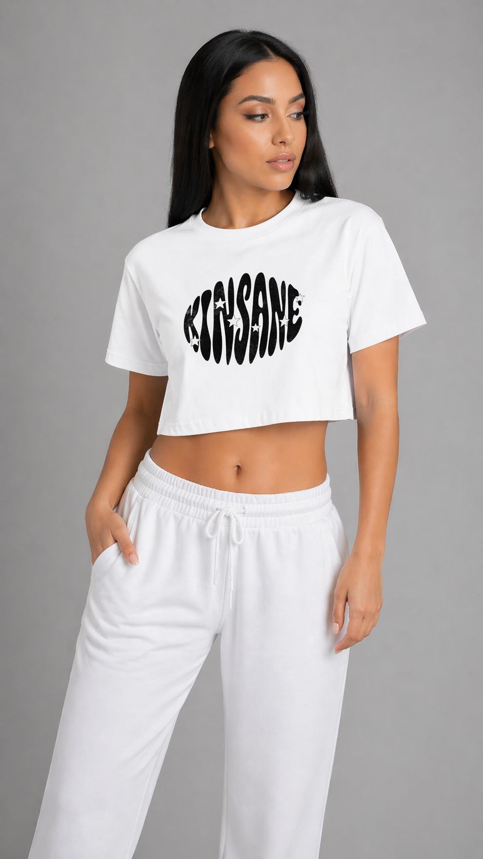 Girl wearing a White crop top T-shirt with black groovy style lettering reading “KINSANE” 