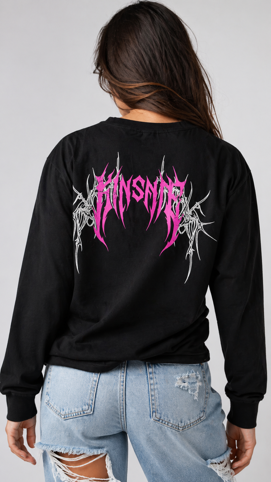 Back view of a girl wearing black long sleeve T-shirt with pink tribal lettering reading “KINSANE” and white tribal designs