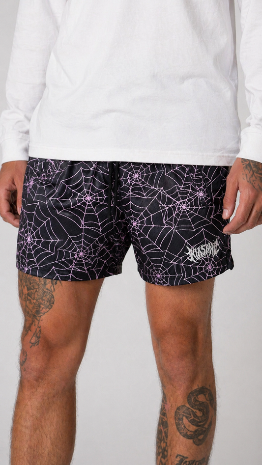 Man wearing Black shorts with pink web design and white text reading “KINSANE” 