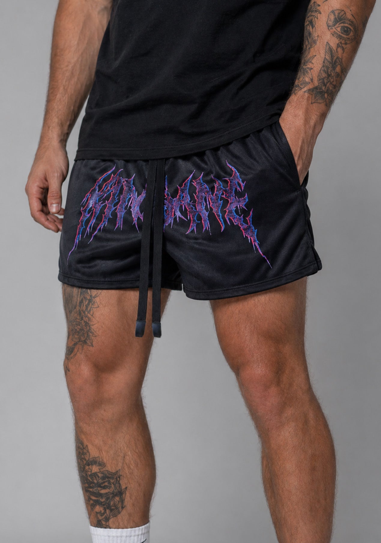 Black athletic shorts with elastic waistband and black drawstrings with red and purple tribal lettering reading “KINSANE” across the middle 