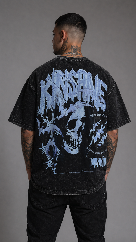 Back view of a man wearing a black acid washed t-shirt with a skull design and white lettering reading “KINSANE” and “KINSANE CLAN KNOWN GRIM REAPERS” 