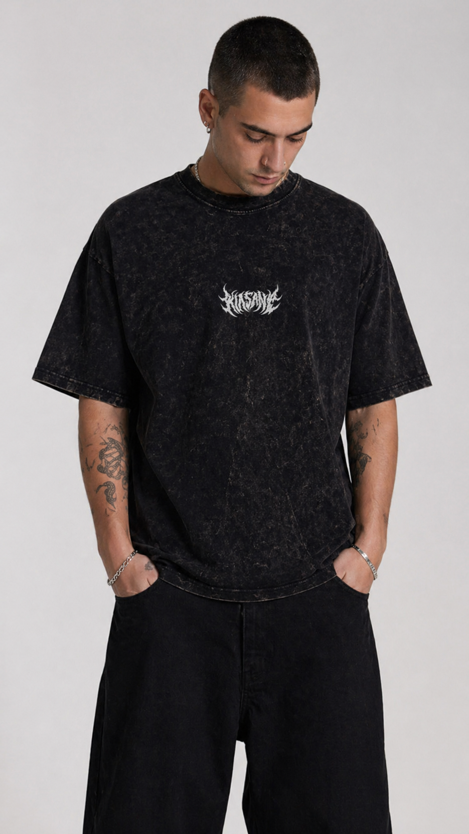 Man wearing Black acid washed t shirt with white text reading “KINSANE” 