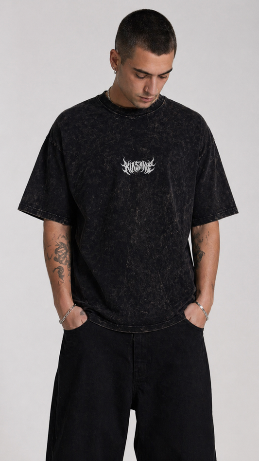 Man wearing Black acid washed t shirt with white text reading “KINSANE” 